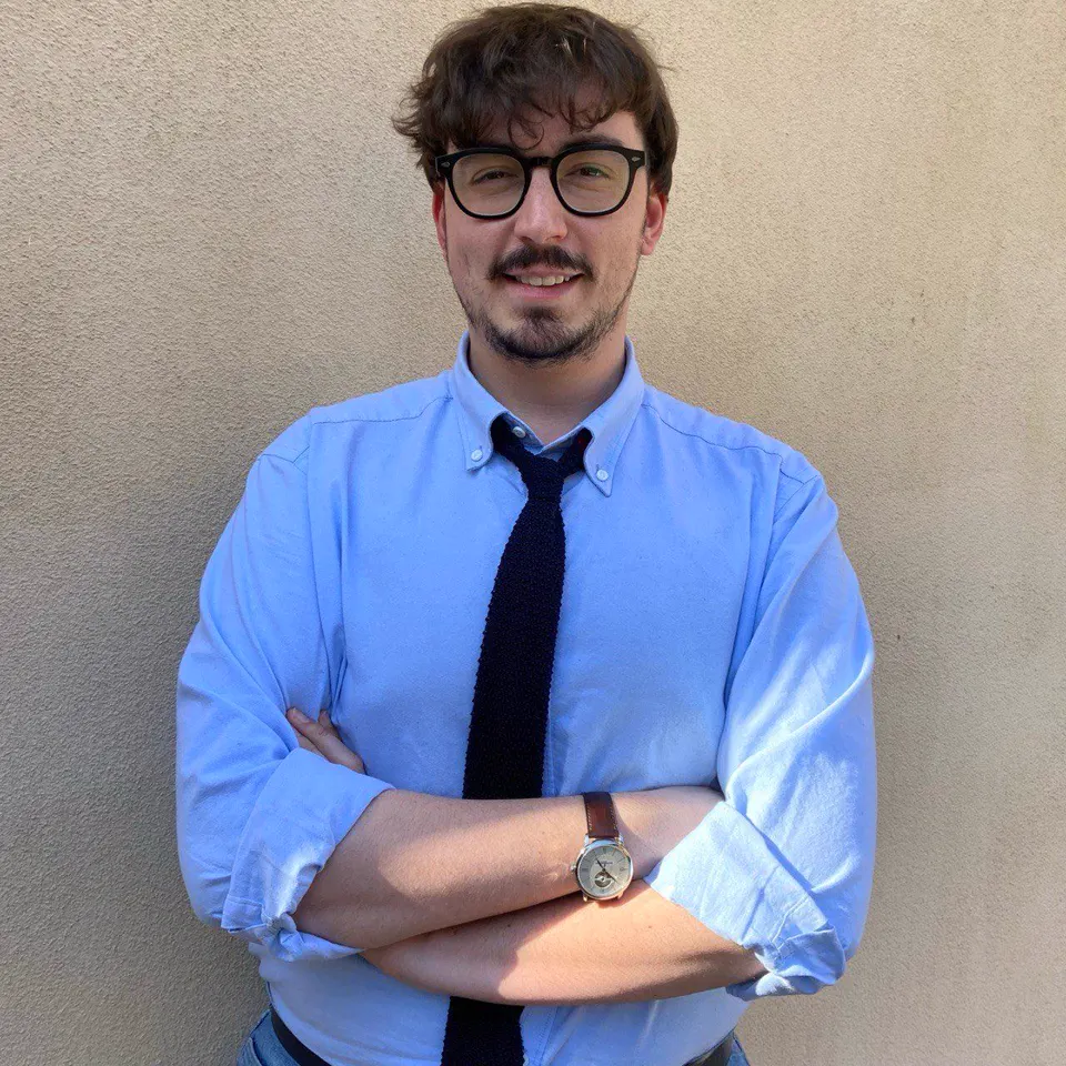 Alessandro Soldà, fondatore di Work Is Business, a braccia conserte davanti a una parete chiara